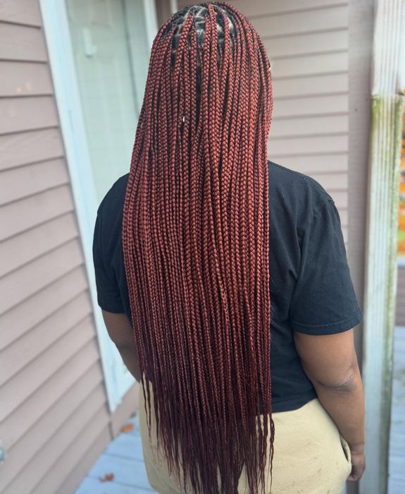 Long reddish-brown knotless braids styled at House of Braids CT, shown from the back