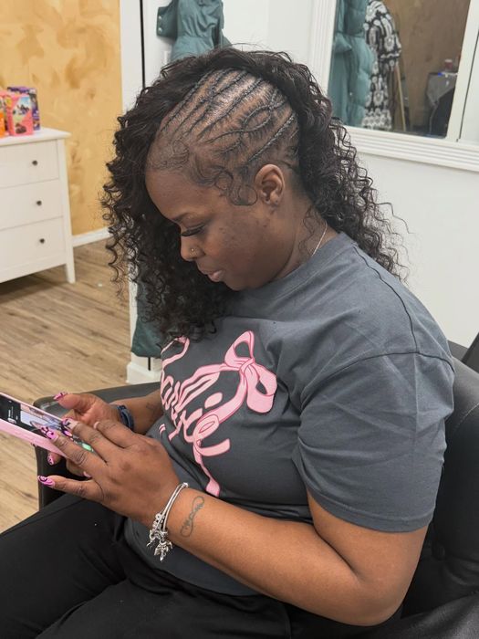 Feed-in cornrows transitioning into curly hair, side profile in the shop