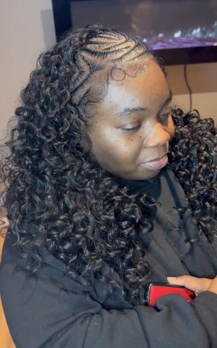 Intricate geometric feed-in braid parting at the crown into curly hair