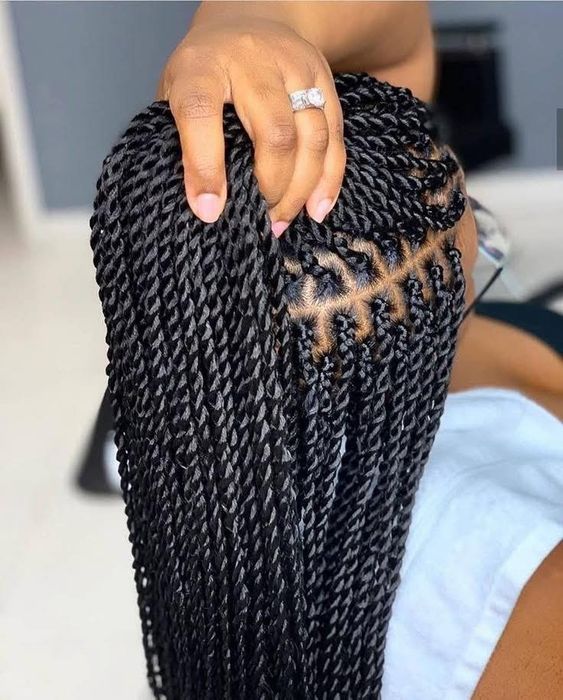 Close-up top-down view of clean cornrow parting into twists