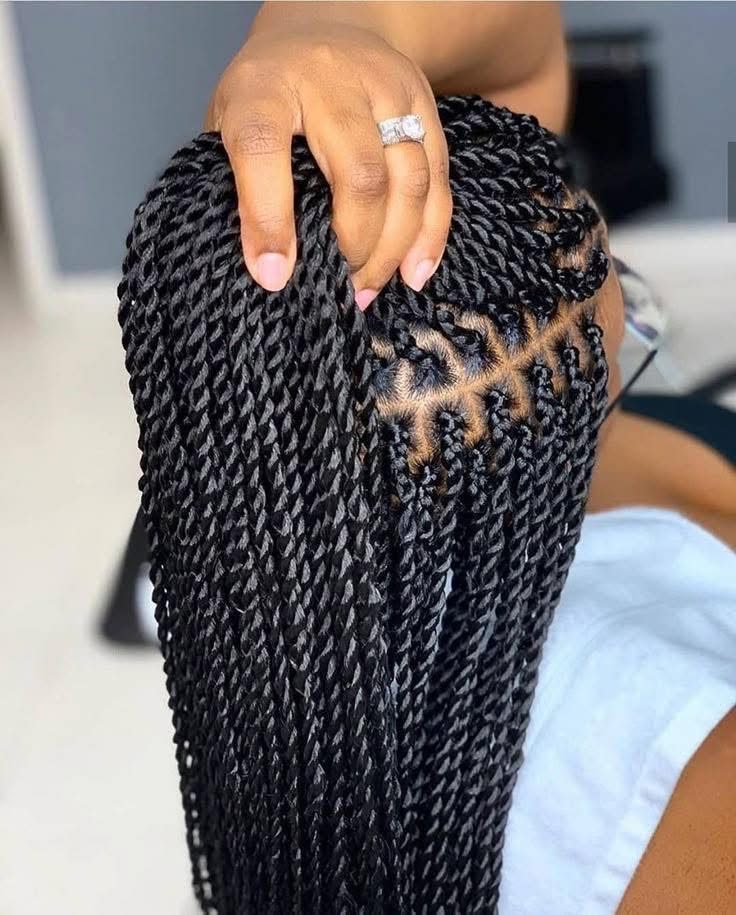 Close-up top-down view of clean cornrow parting into twists
